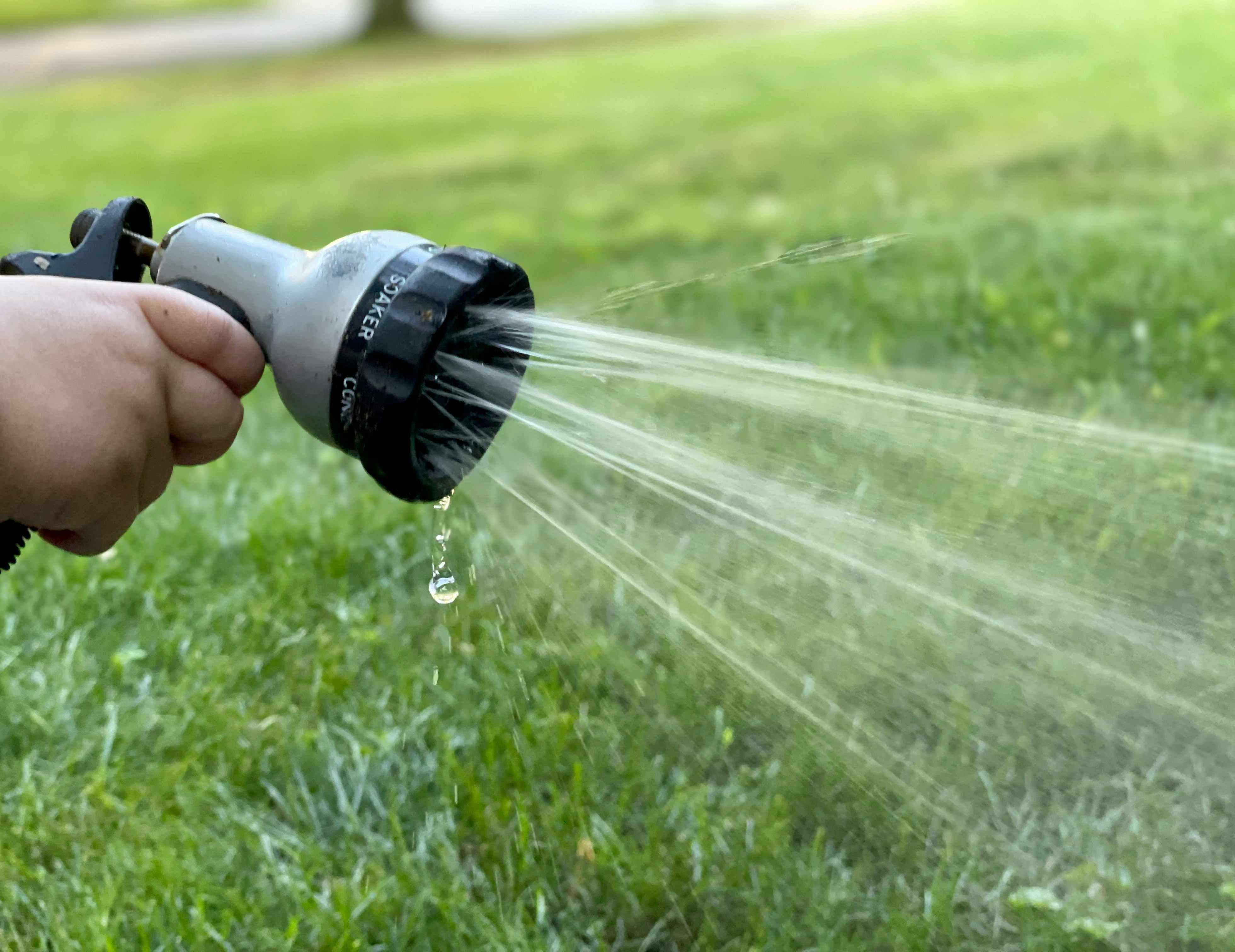 Child's hand holding hose nozzle